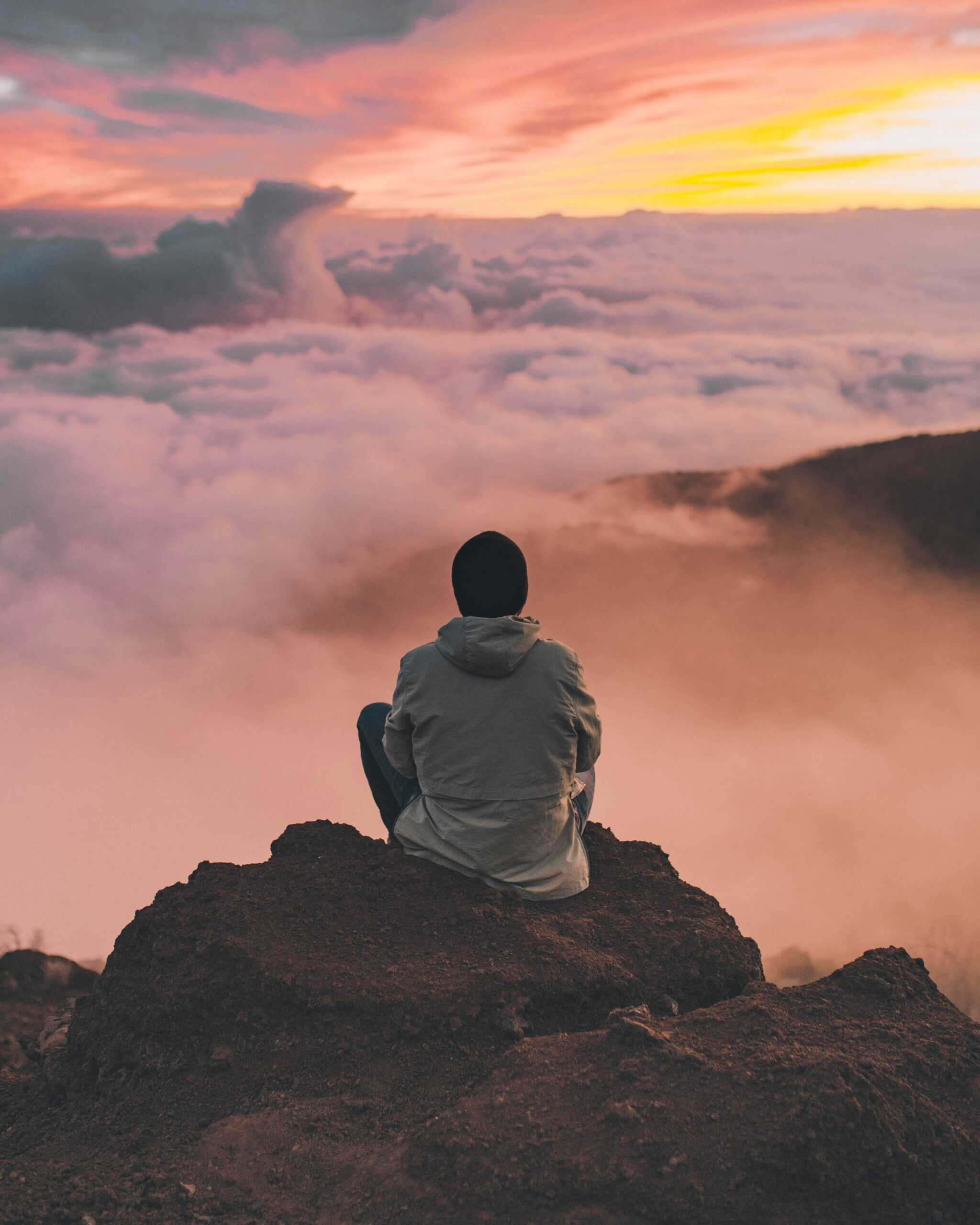 Image of a man meditating at the top of mountain